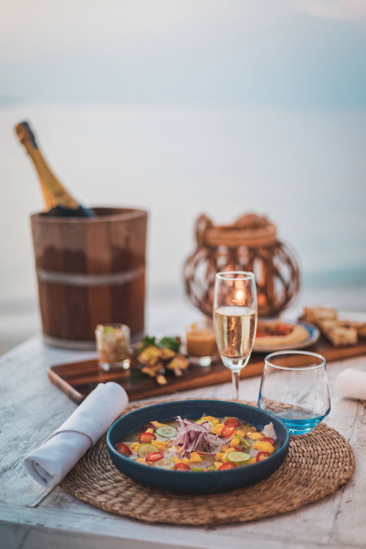 Table setting with Champagne in a wooden bucket and food on a plate