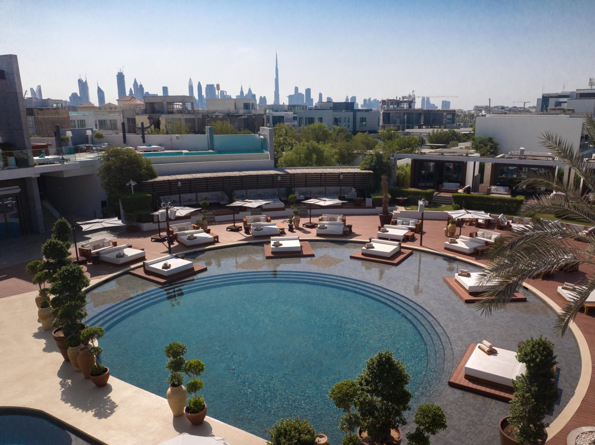 Pool area with sunbeds, the city skyline can be seen in the distance