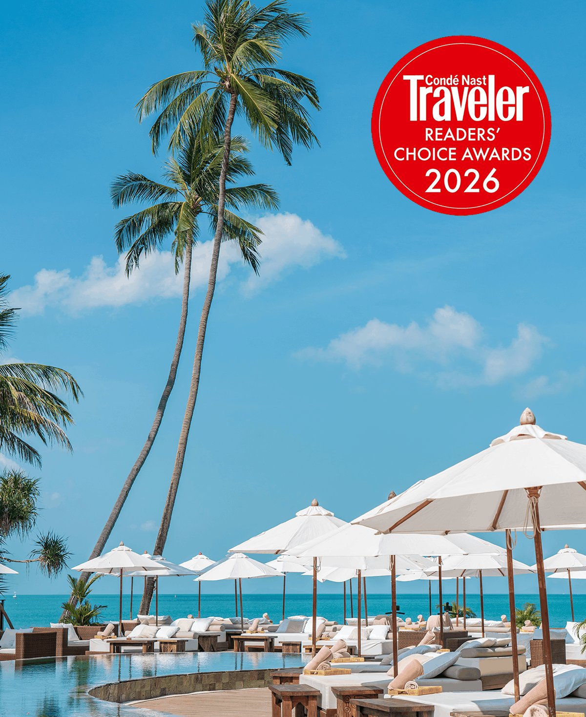 A serene tropical scene featuring a curved swimming pool lined with plush white daybeds, white umbrellas, and tall palm trees reaching into a clear blue sky. The image includes a red Condé Nast Traveler Readers' Choice Awards 2026 badge