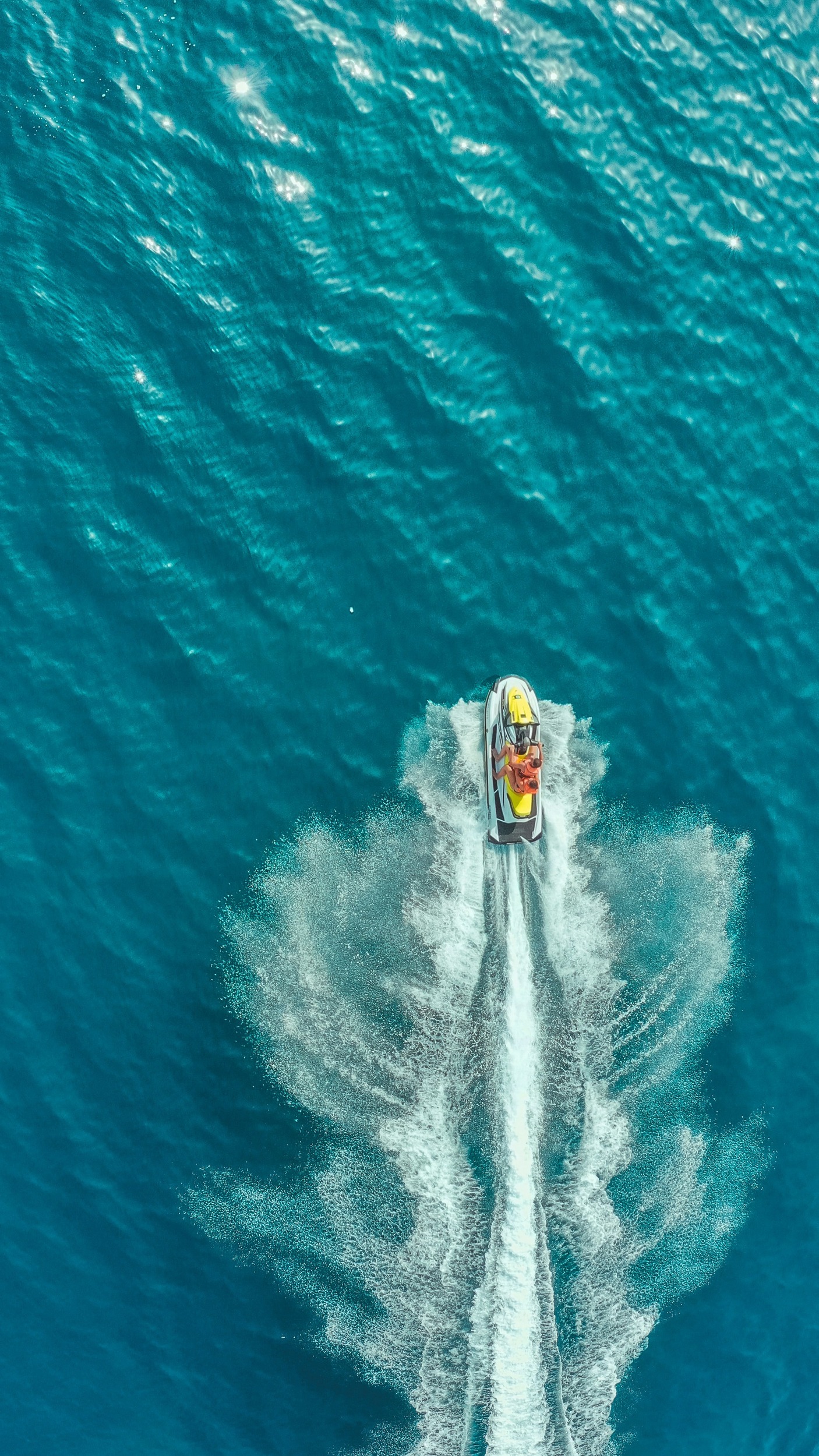 Aerial view of a sleek jet ski gliding over the vibrant blue ocean, showcasing Dubai's thrilling watersport adventures