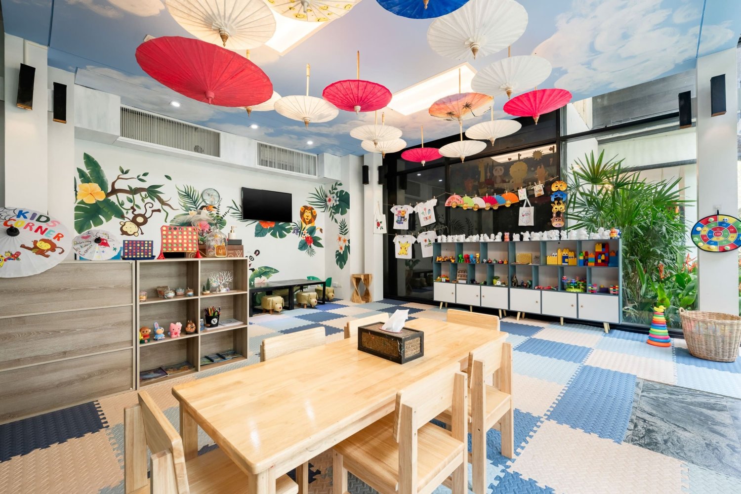 A delightful playroom with colorful umbrellas suspended above, offering a playful and inspiring space for young guests to enjoy