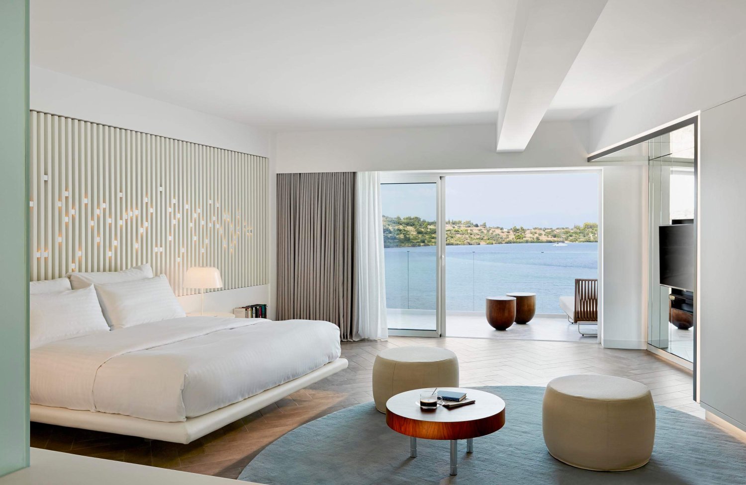 Double bed room with small seating area and a sea view balcony