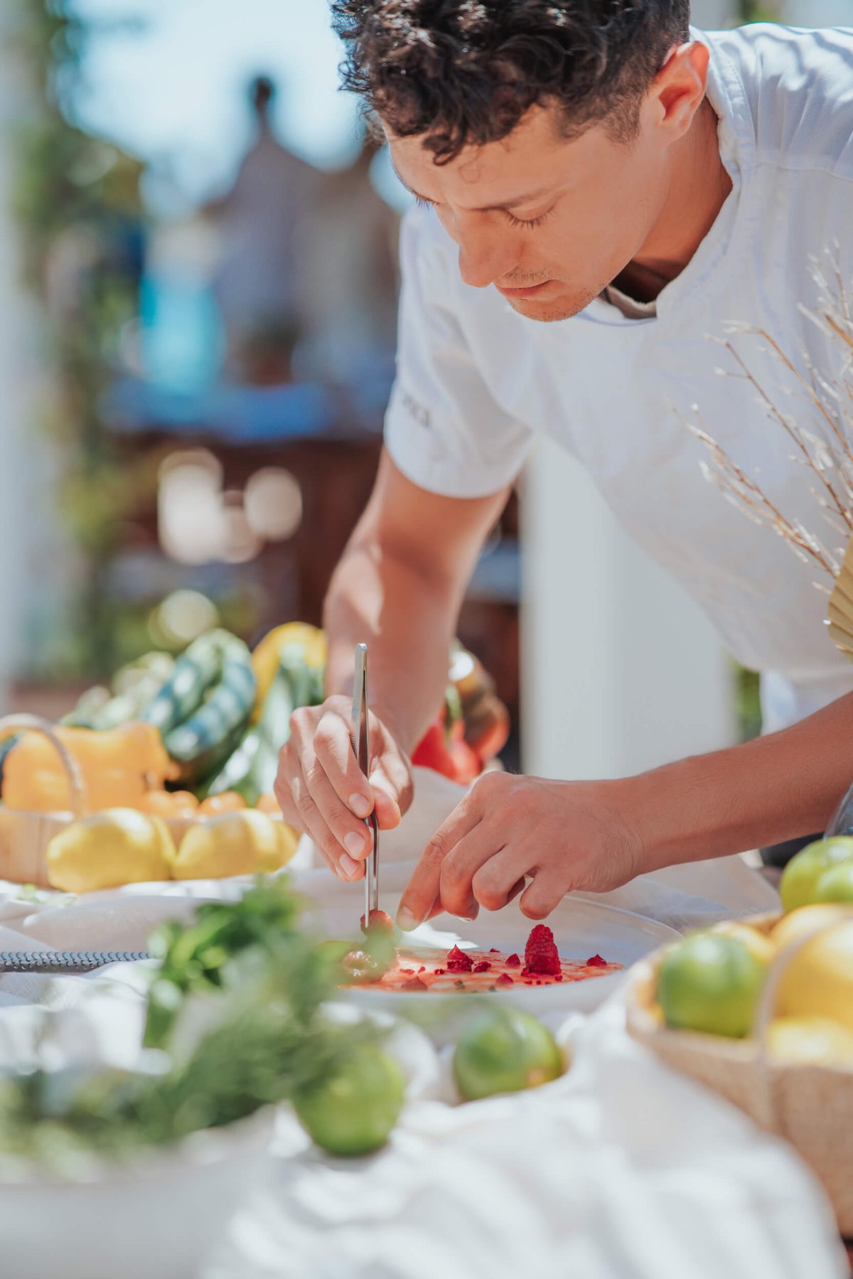 Chef topping off a plate of food with garnish
