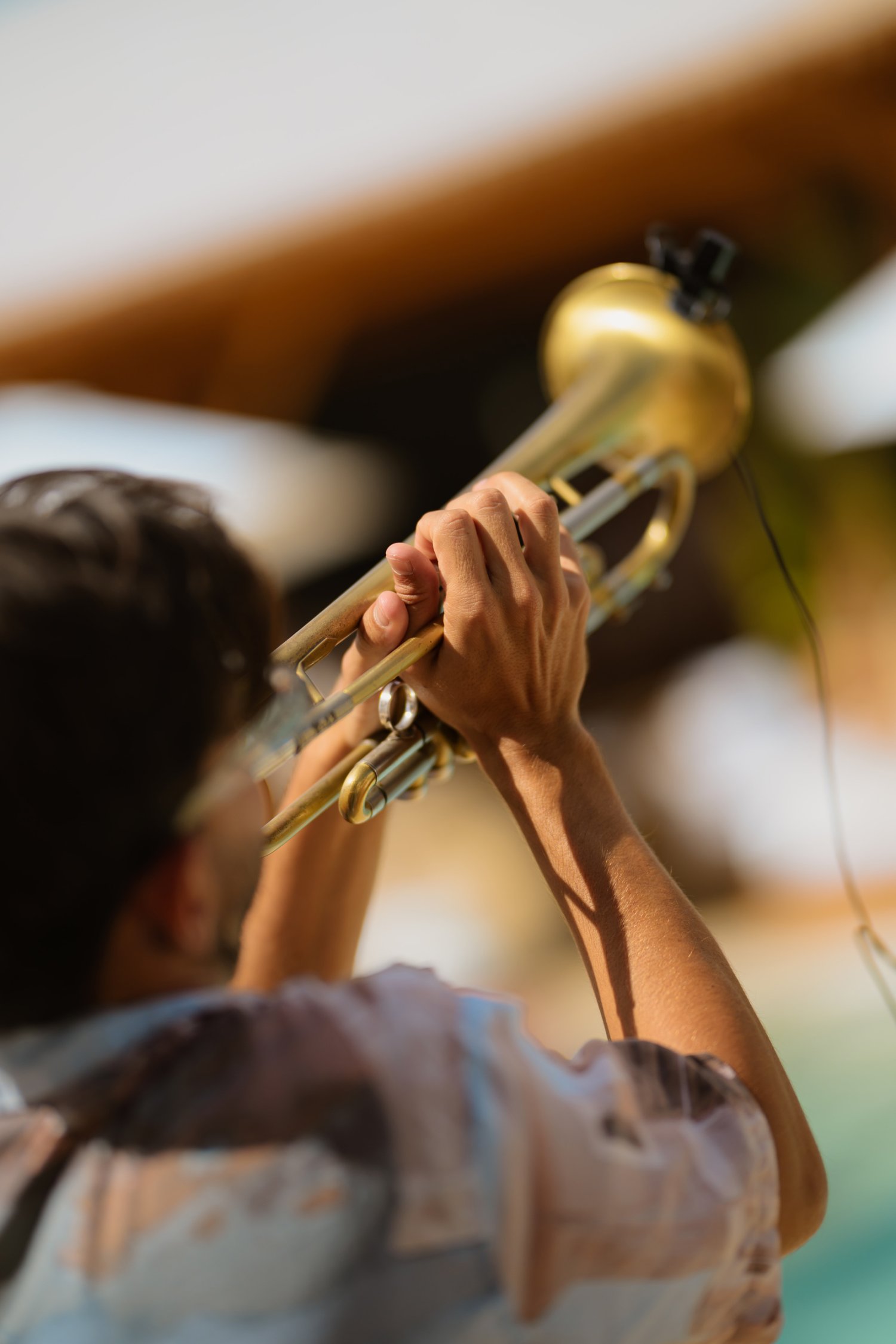 Guy playing the trumpet, view from behind