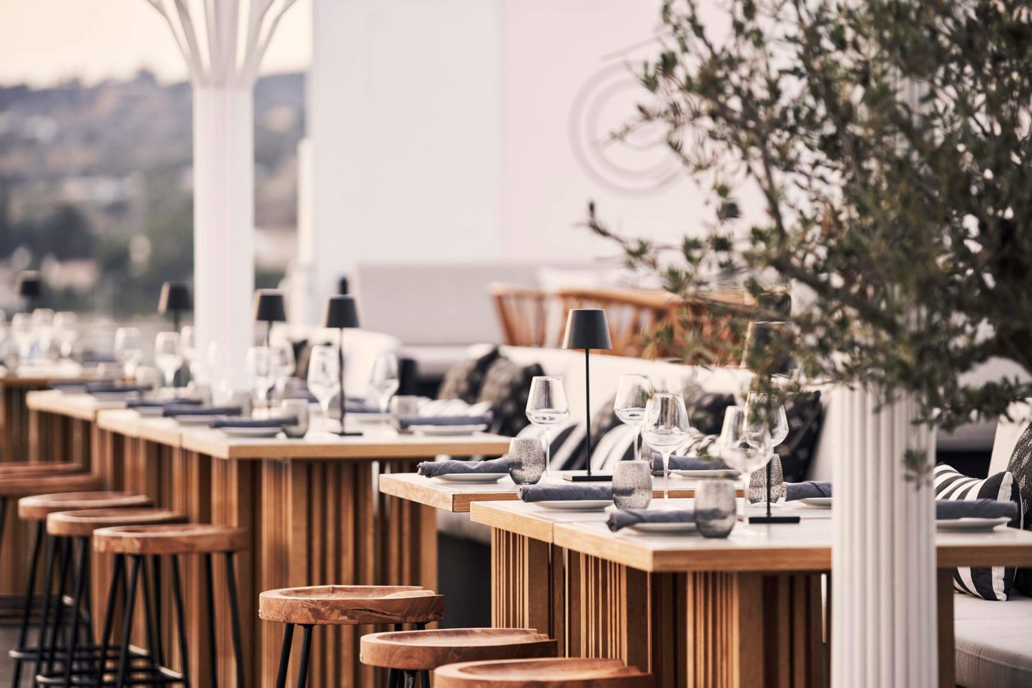 An outdoor dining area with multiple laid tables