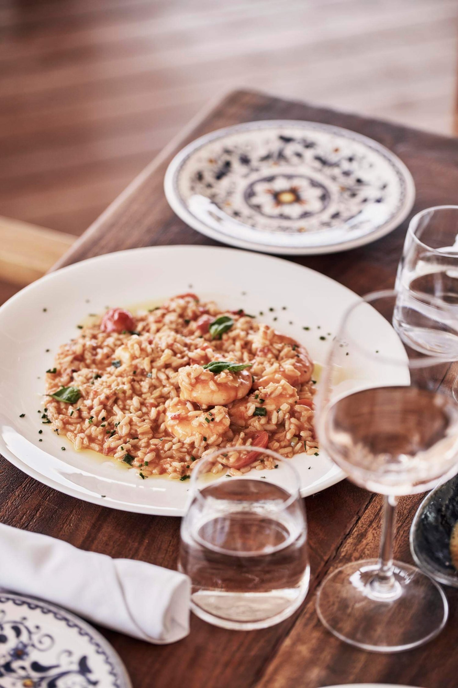 Risotto dish served with glasses of wine and water