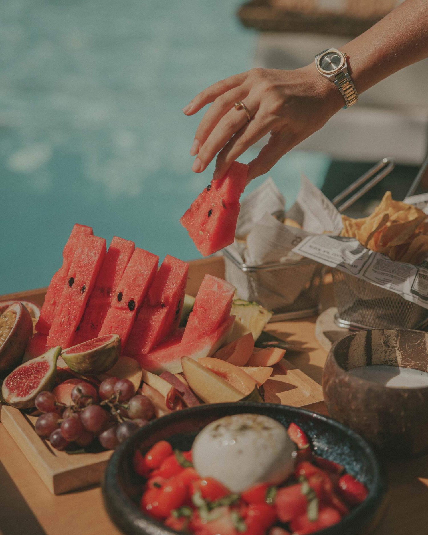 A women picking a piece of watermelon from a fruit platter