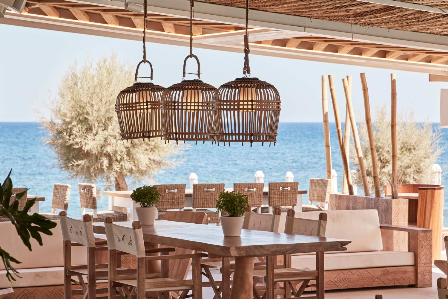 Indoor seating area for Nikki Beach Santorini with woven hanging lights above the table