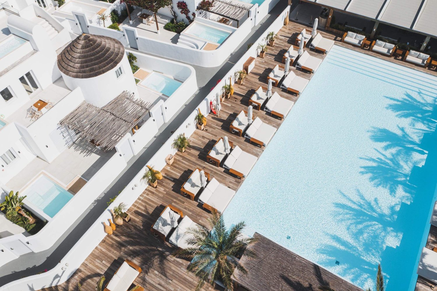 Ariel shot of Nikki Beach Santorini's pool area with sunbeds and sofas