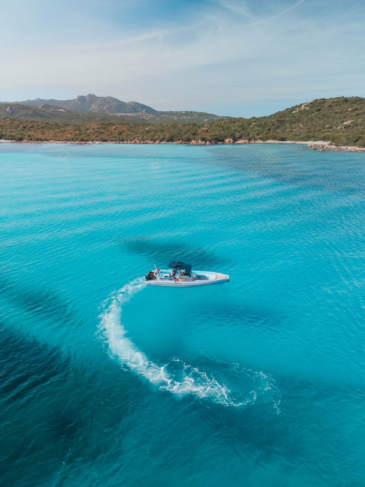 Drone shot of a small boat turning in the sea
