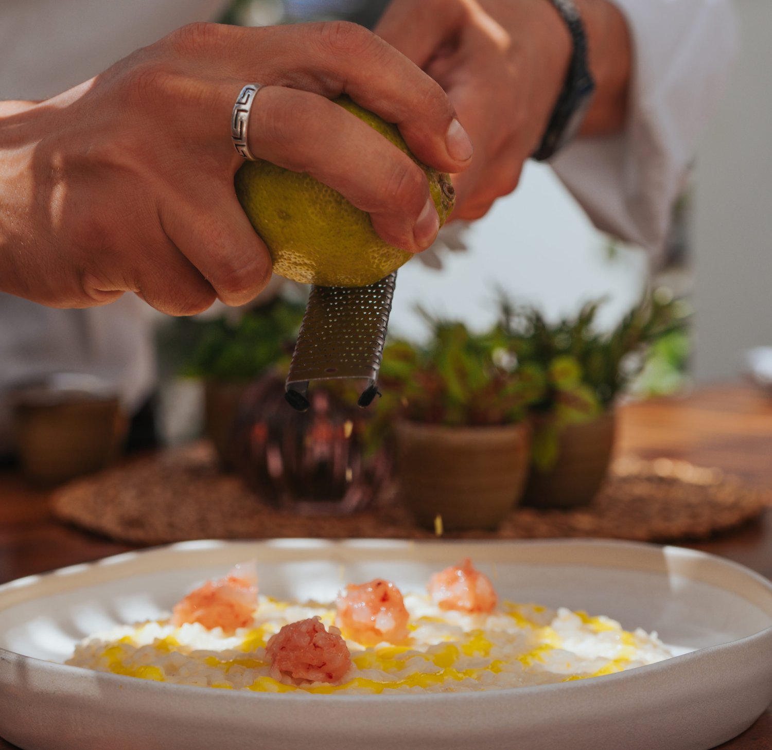 Chef grating garnish over a dish
