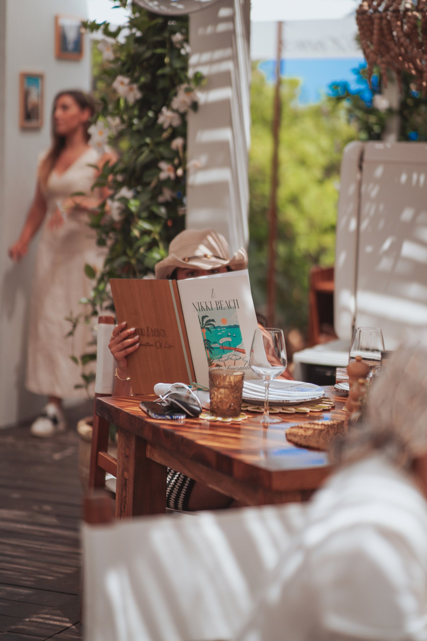 A women reading the Nikki beach menu sat at her table