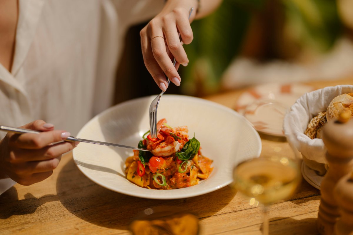 A lady eating a prawn dish