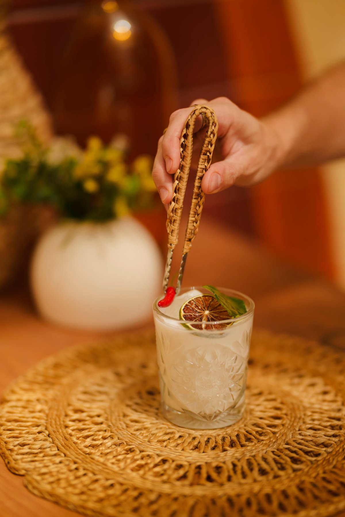 Waiter garnishing a cocktail with a chilli