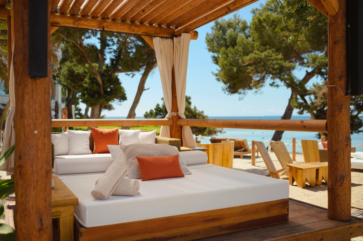 A close up of a sun bed under a wooden canopy