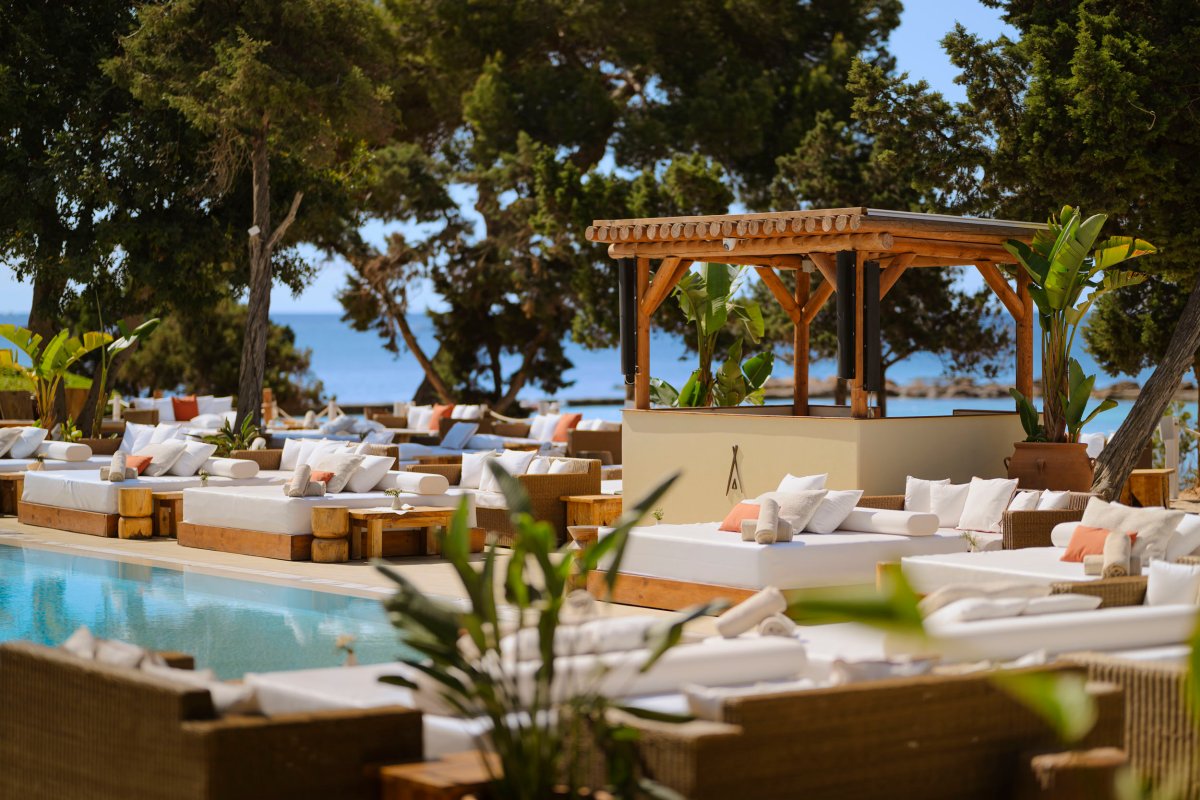 outdoor image of the pool area and DJ booth surrounded by sunbeds