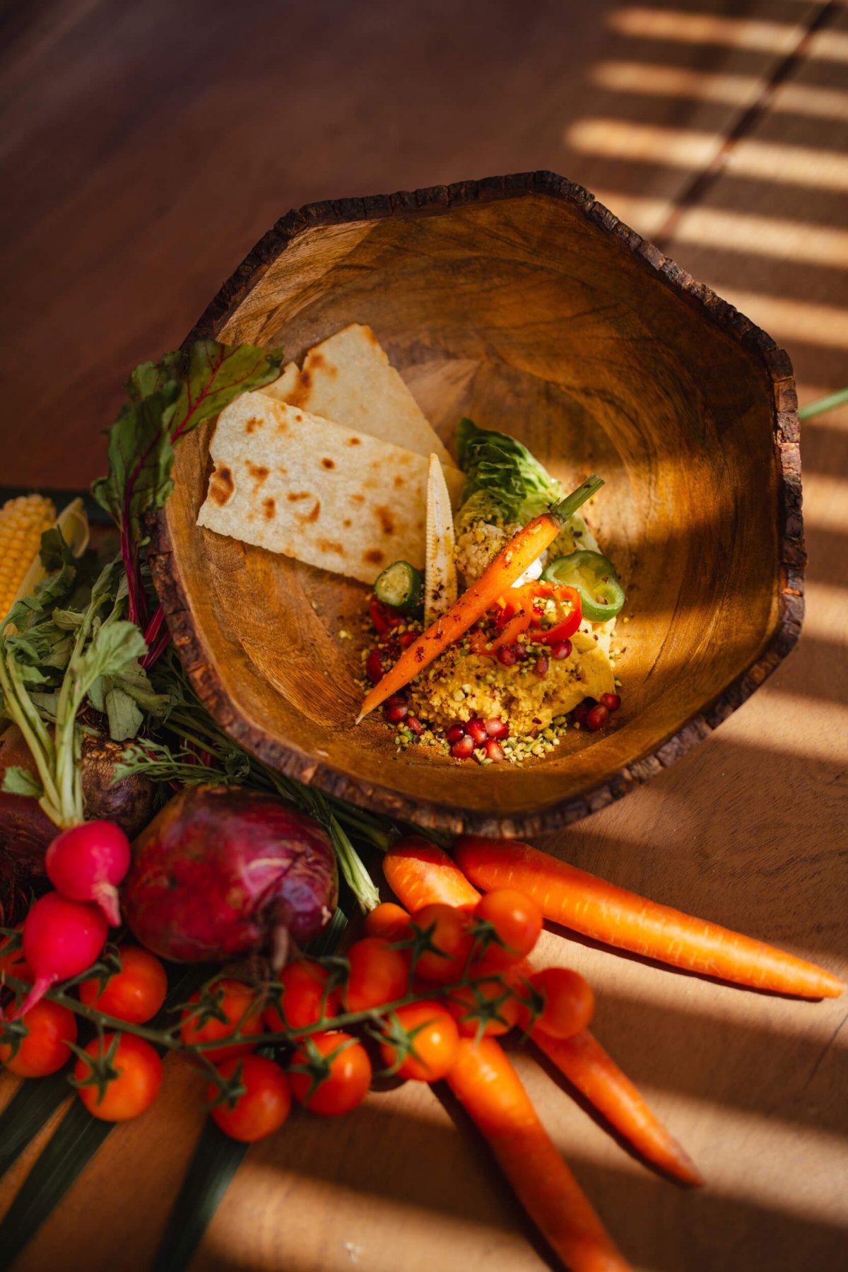 Plate of food and surrounded by tomatoes and carrots