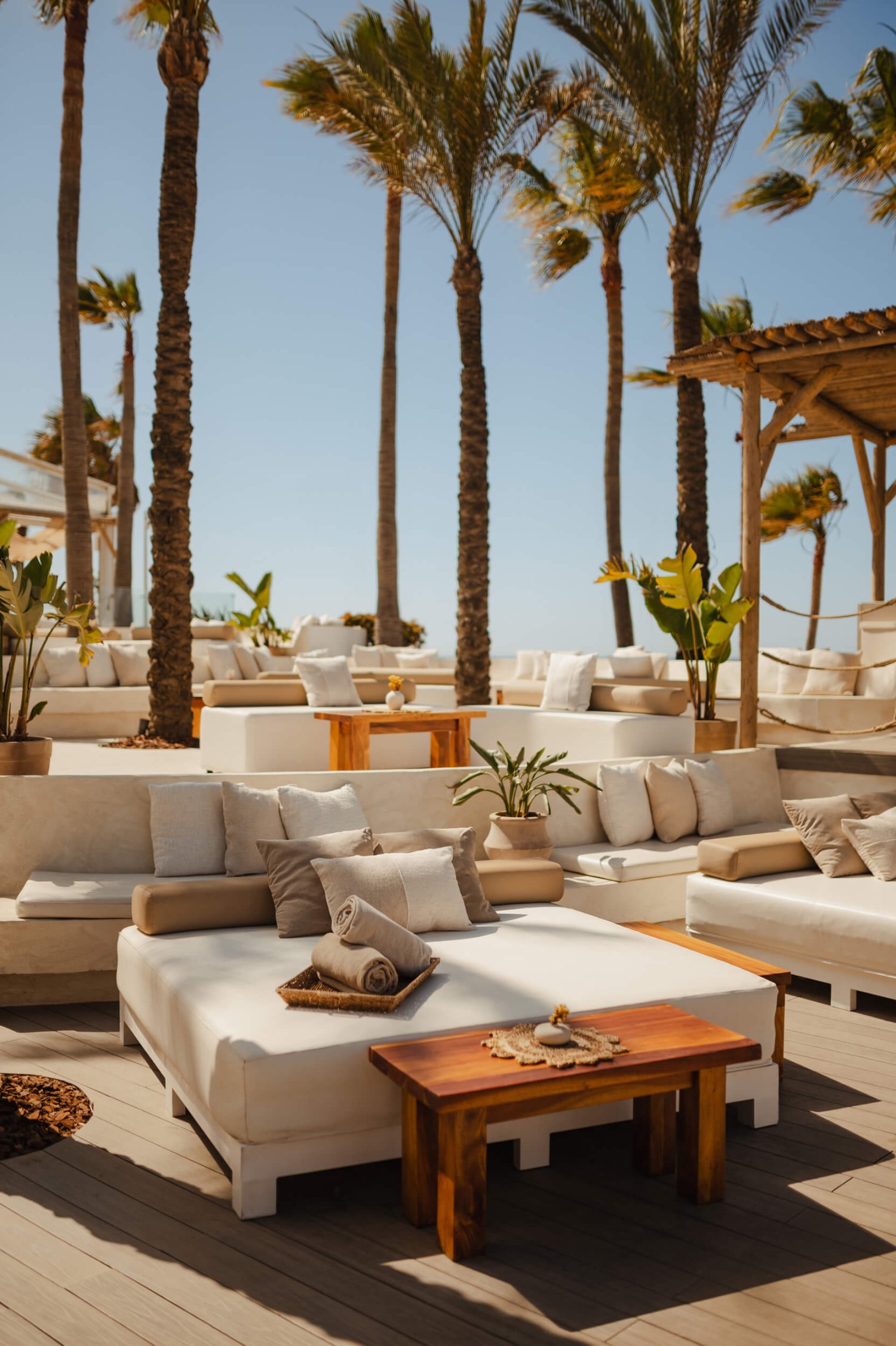 Nikki Beach Marbella Exterior, sun beds and sofas with cushions, towels and small coffee table