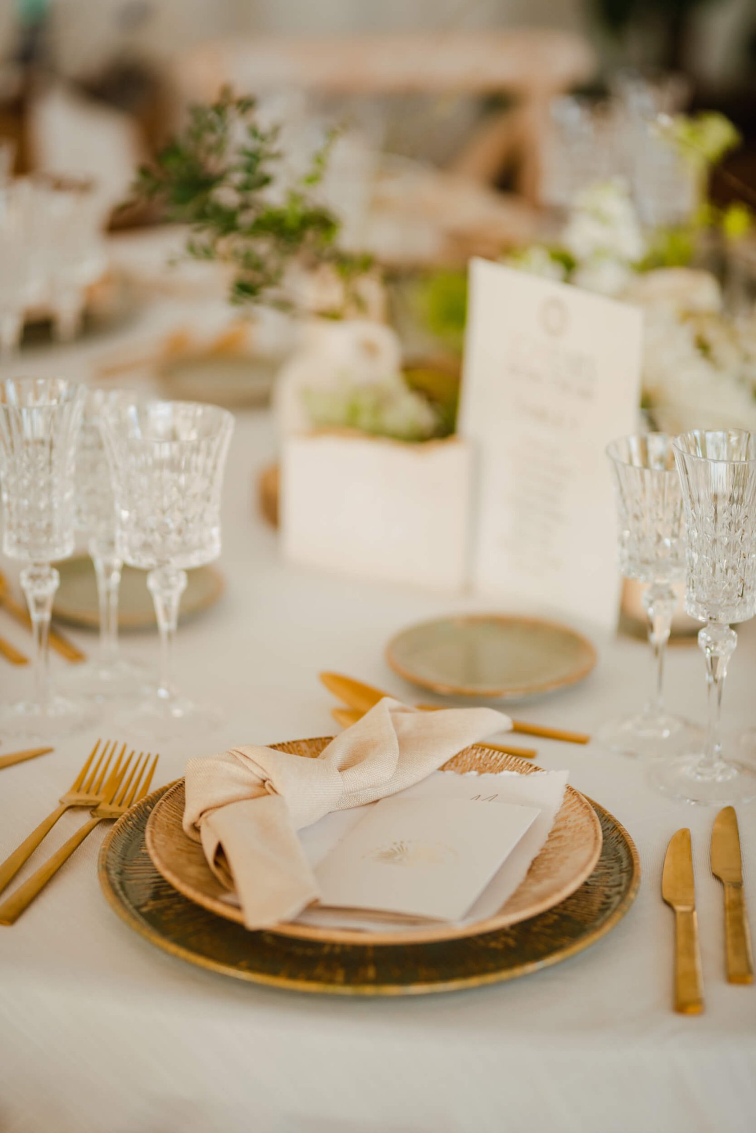 Close up of table place setting with gold cutlery and plates