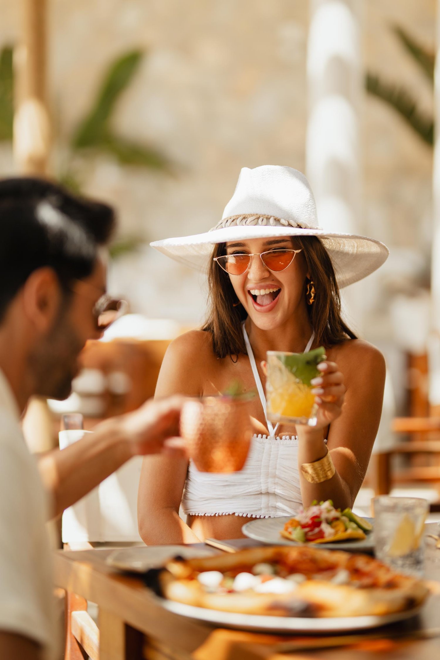 A young lady smiling, holding a cocktail in hand