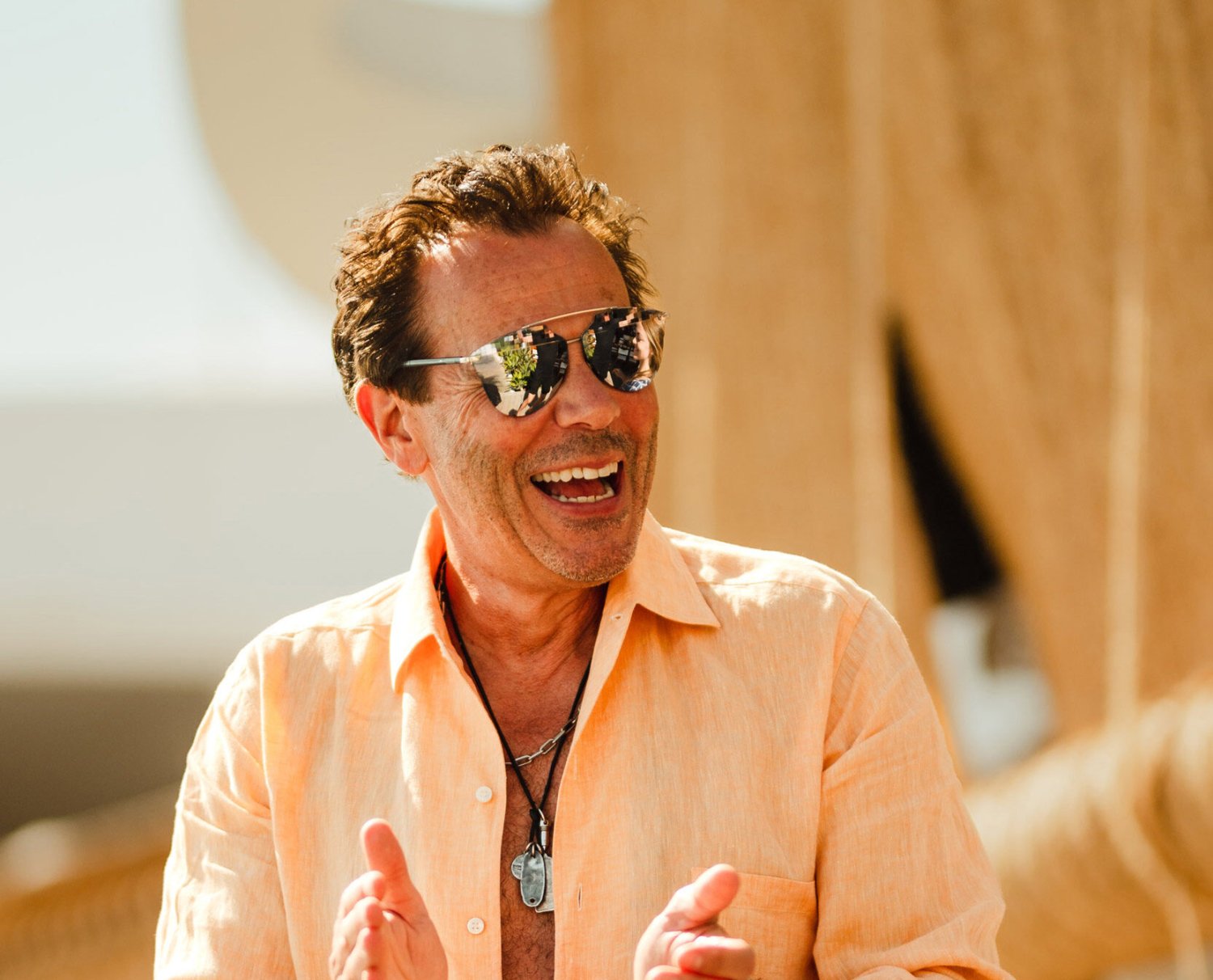 A man in sunglasses smiling and clapping