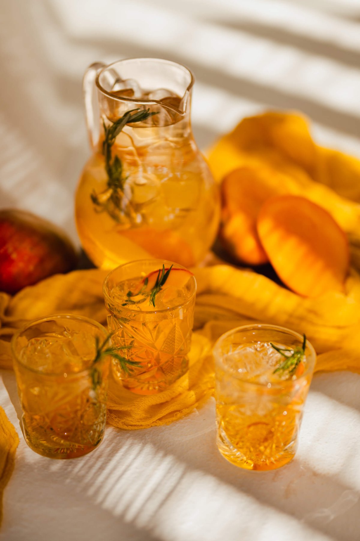 Close up of a jug of orange juice and filled glasses