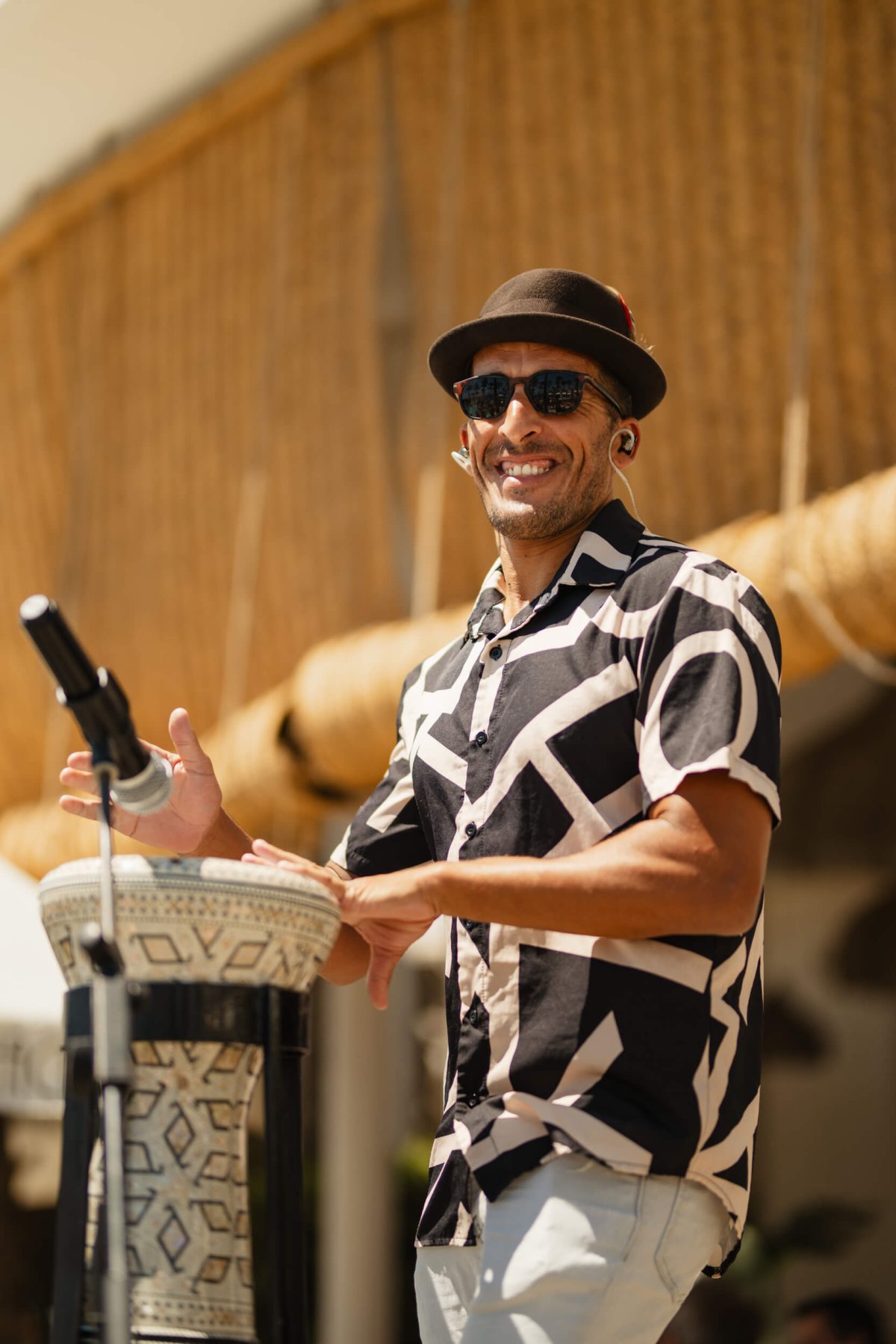 Smiling DJ wearing a hat and black shirt