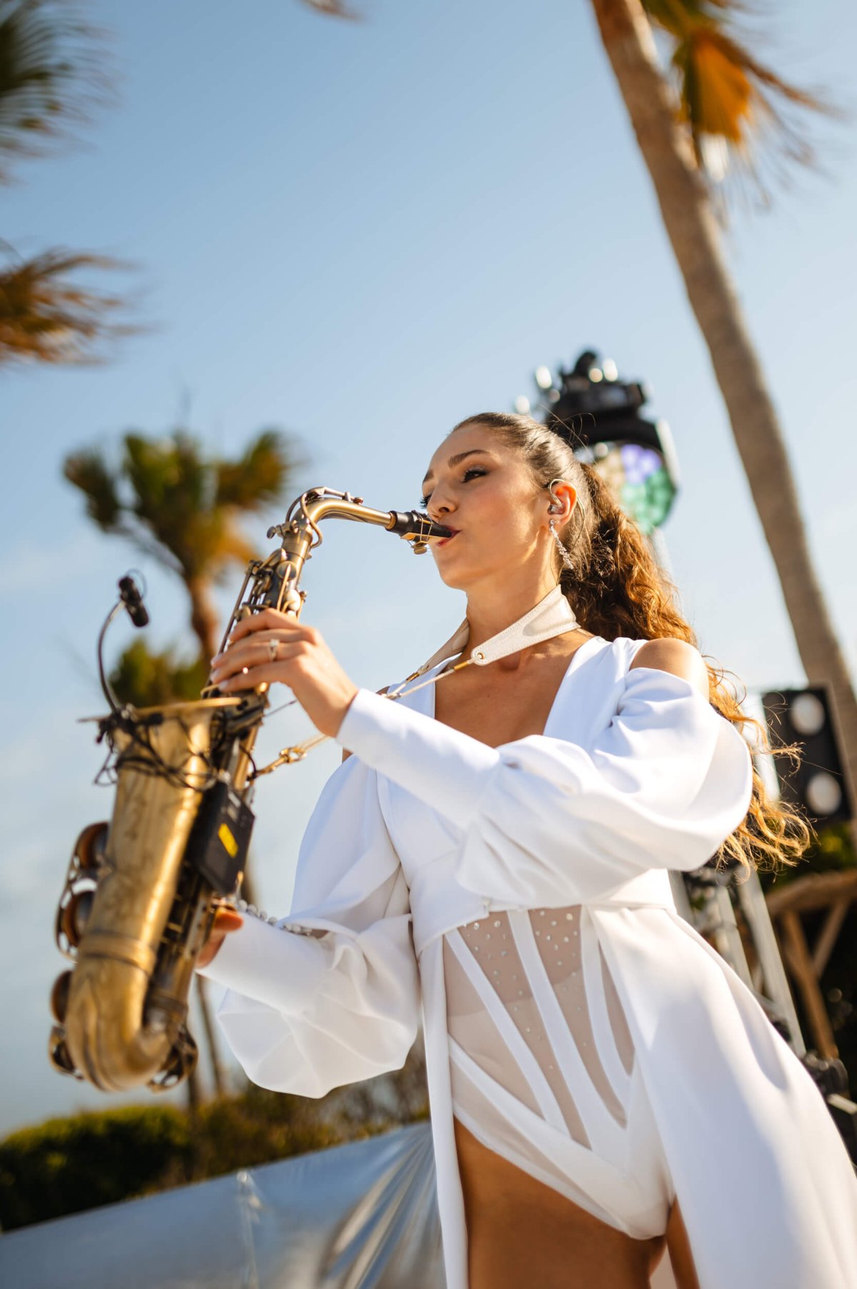 Woman playing the saxophone in a white bikini