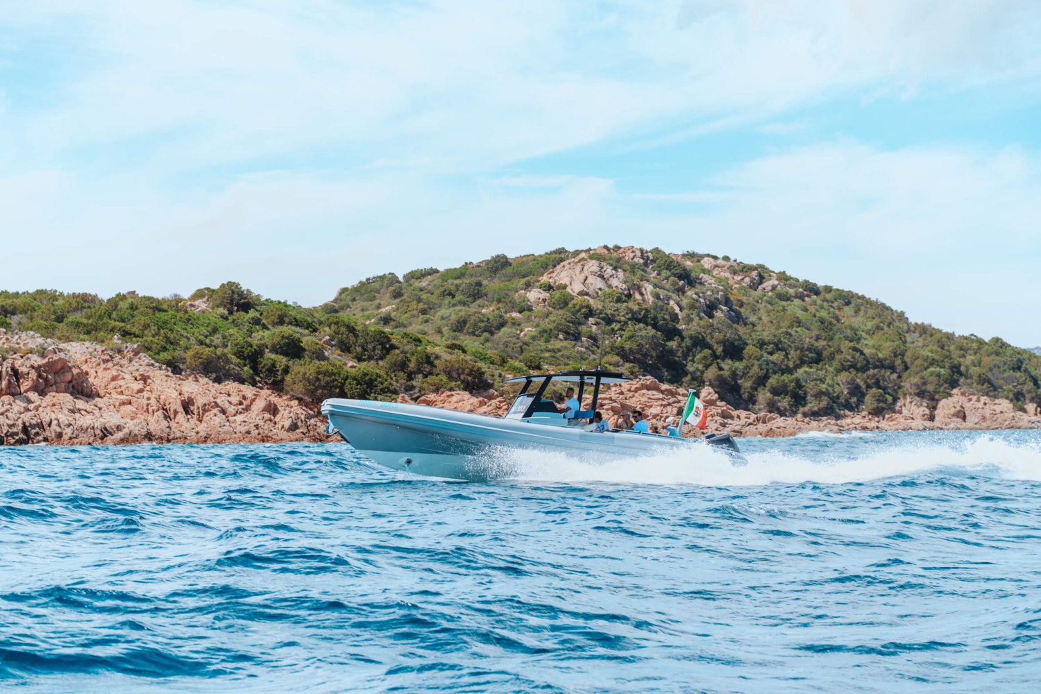 Boat gliding along the sea with mountains in the background