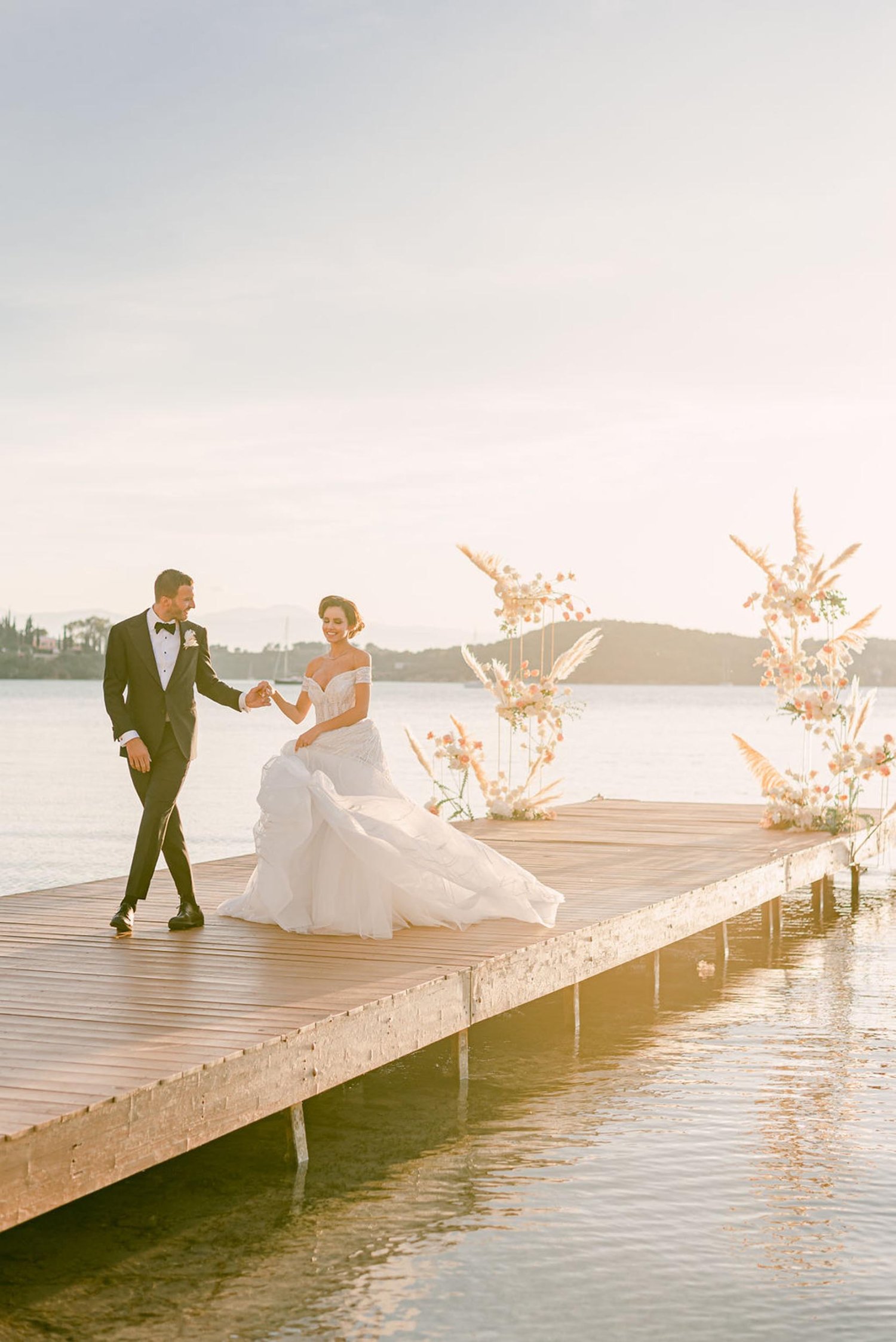 A man and women getting married on a wooden walkway out to the sea