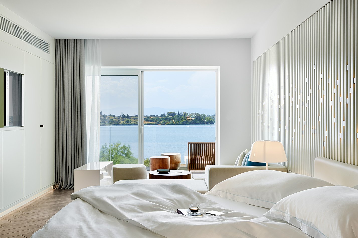 Covet room oversized bed and sofa area looking out to Porto Heli Bay