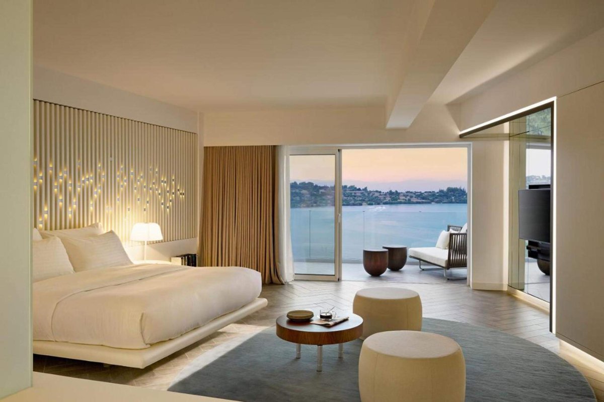 Double bed room with small seating area, kitchen, bath and a sea view balcony