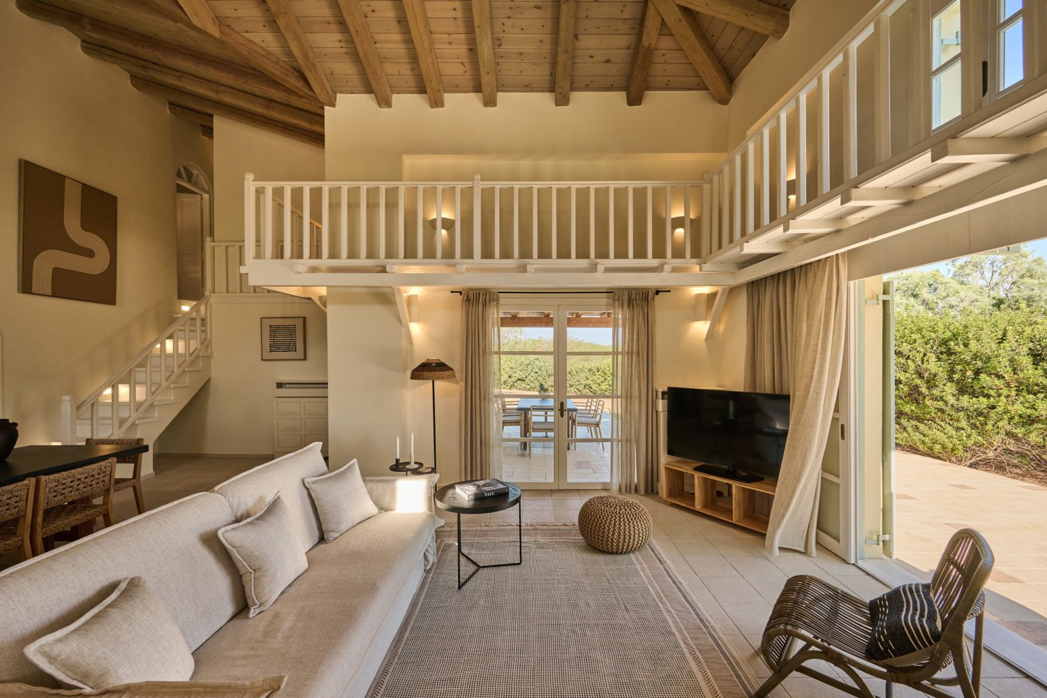 Spacious living room featuring a stylish couch, a sleek TV, and a balcony, ideal for unwinding in a luxury villa