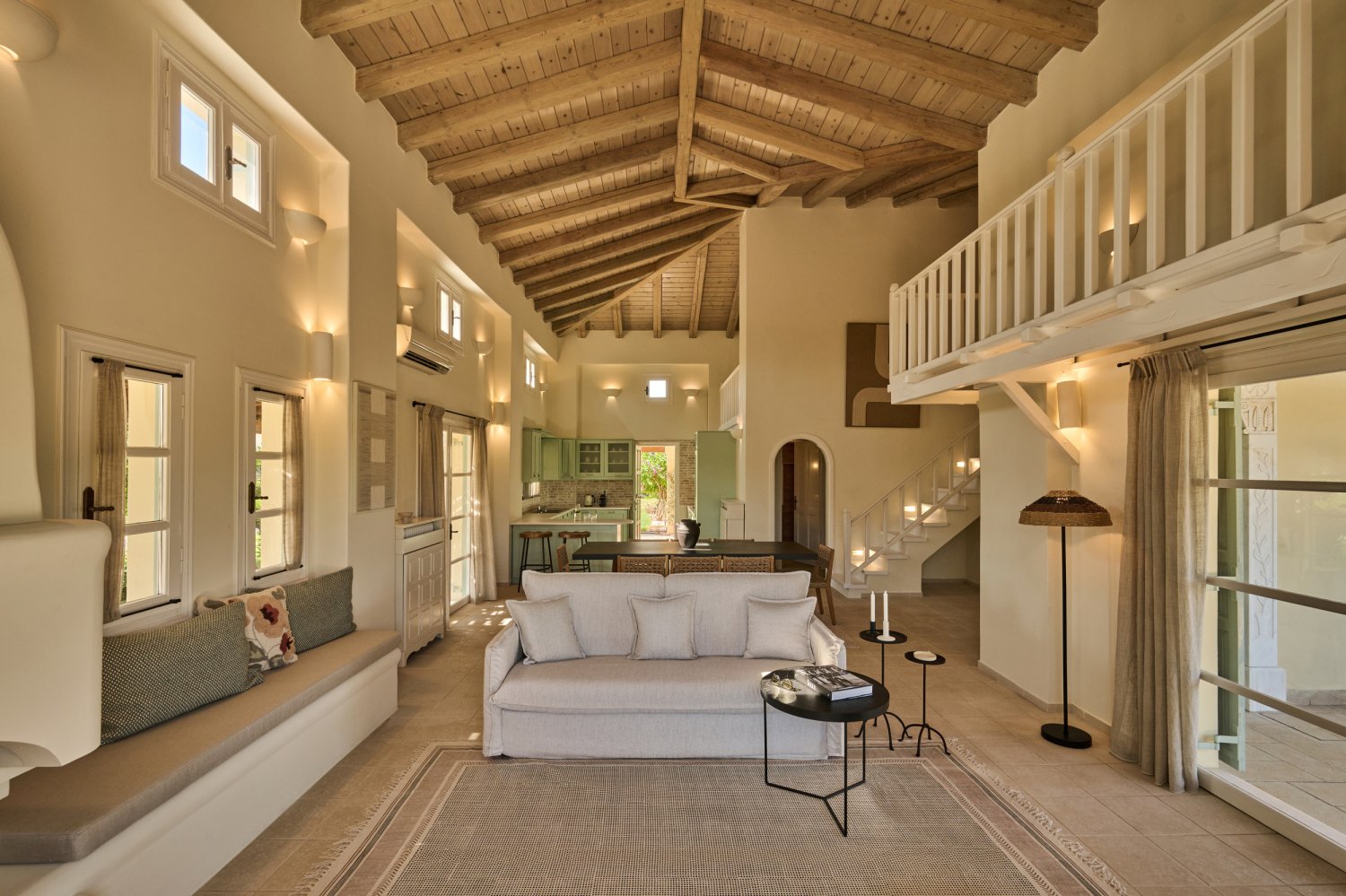 Elegant living area with comfortable sofa and grand staircase, showcasing the refined ambiance of the Oasis 4 Bedroom Villa