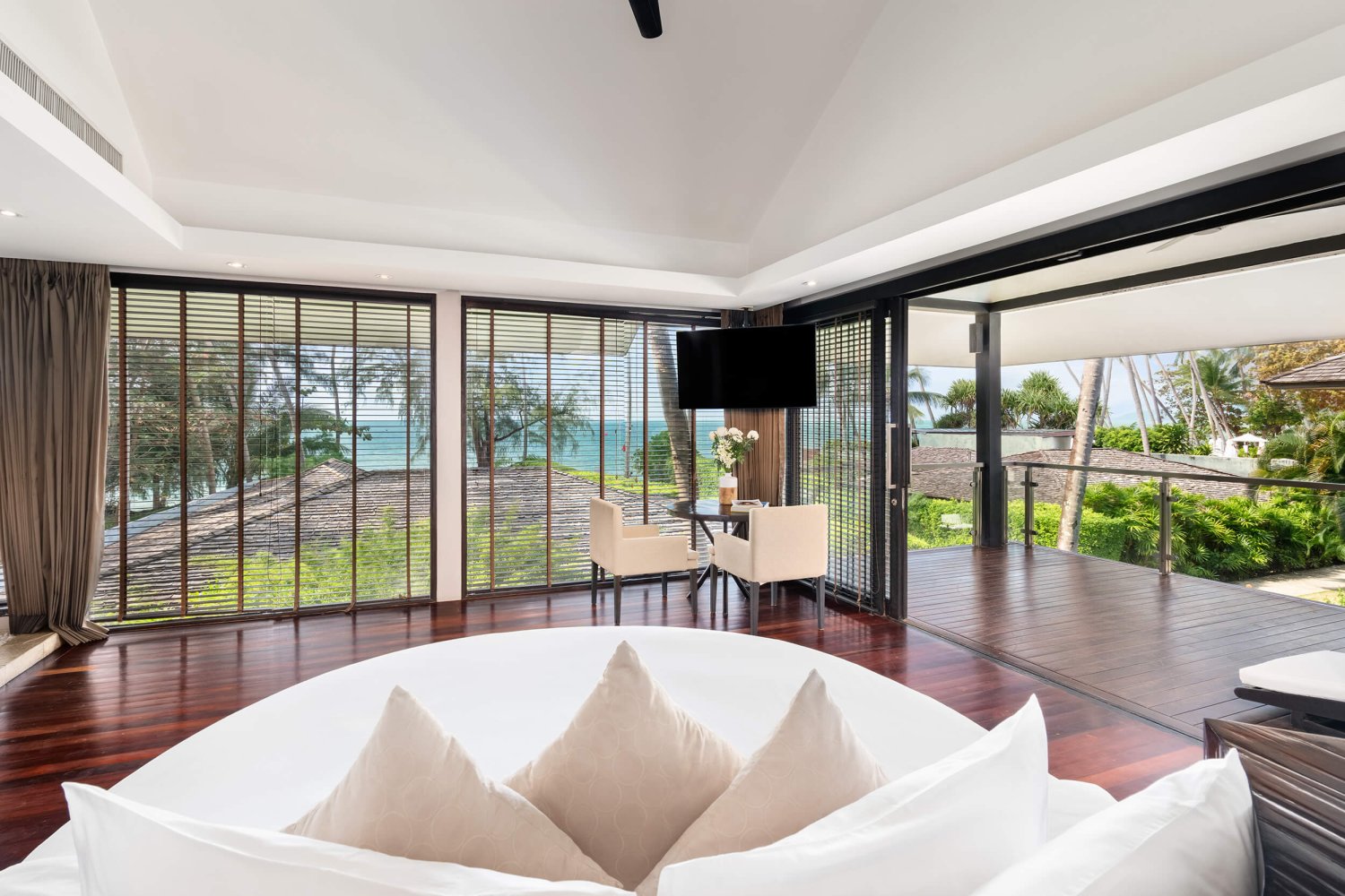 Luux Ocean View Penthouse: Elegant bedroom with a spacious window framing a breathtaking ocean view, inviting tranquility and natural light
