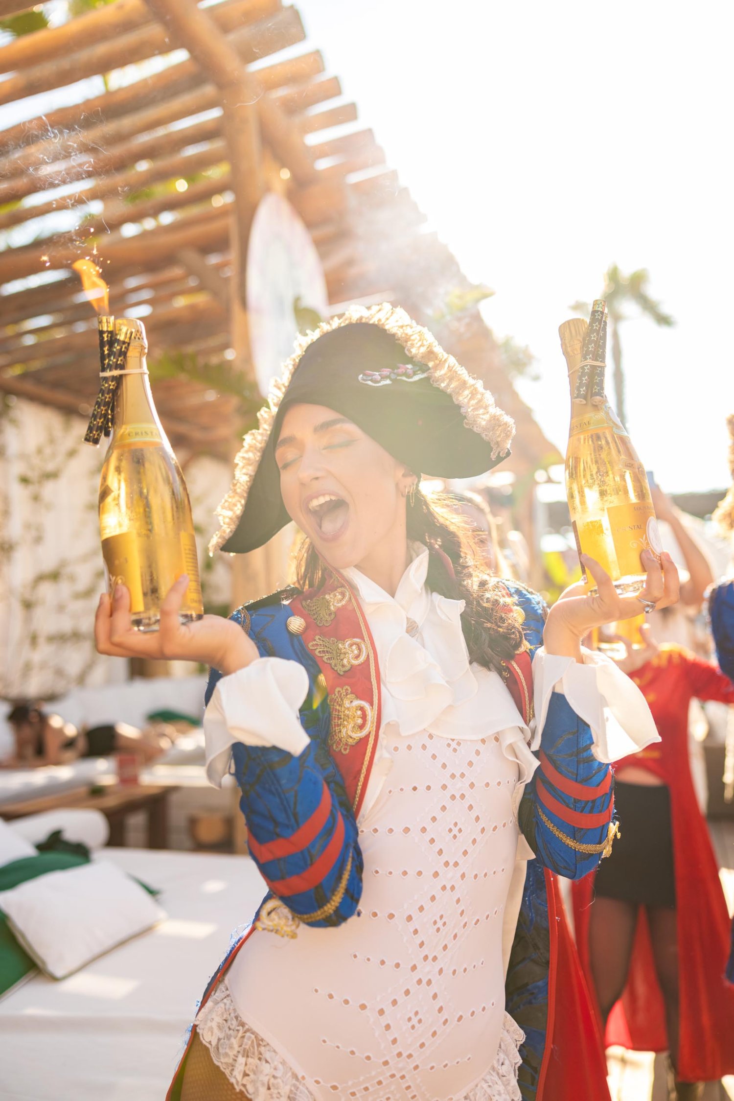 Woman in fancy dress holding two champagne bottles