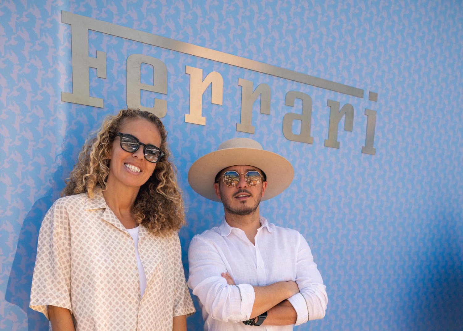guests posing for a photo in front of the Ferrari logo