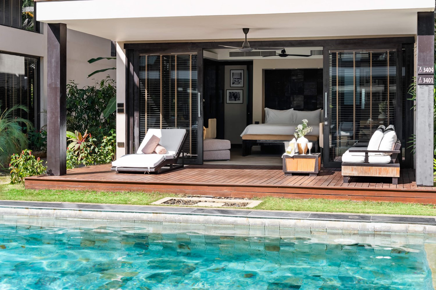 A serene poolside scene featuring a luxurious lounge chair beside a plush bed, inviting relaxation under the sun