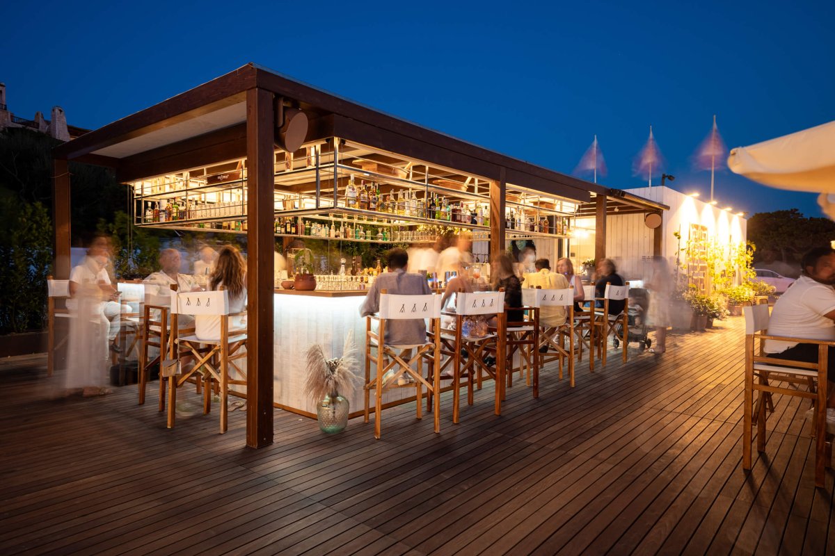 Night time shot of a busy outside bar at Nikki Beach Porto Cervo