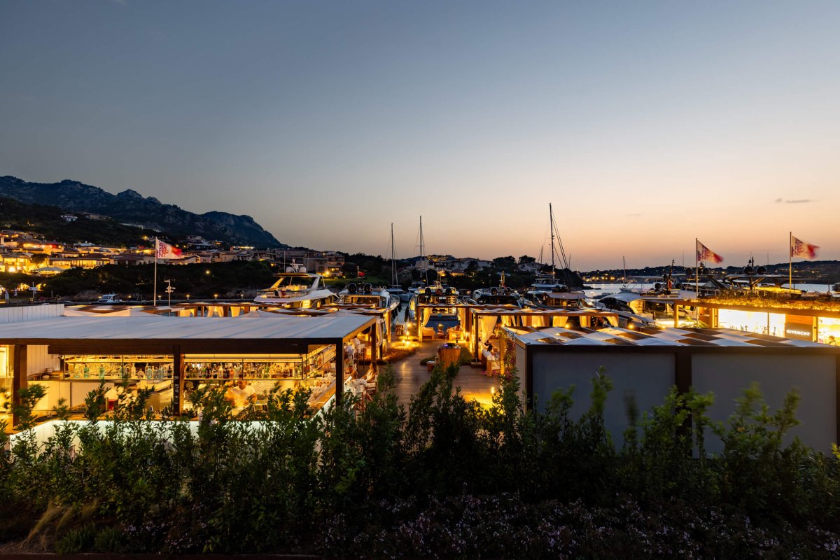 Wide shot of the harbour at Porto Cervo at sunset with the mountains in the background