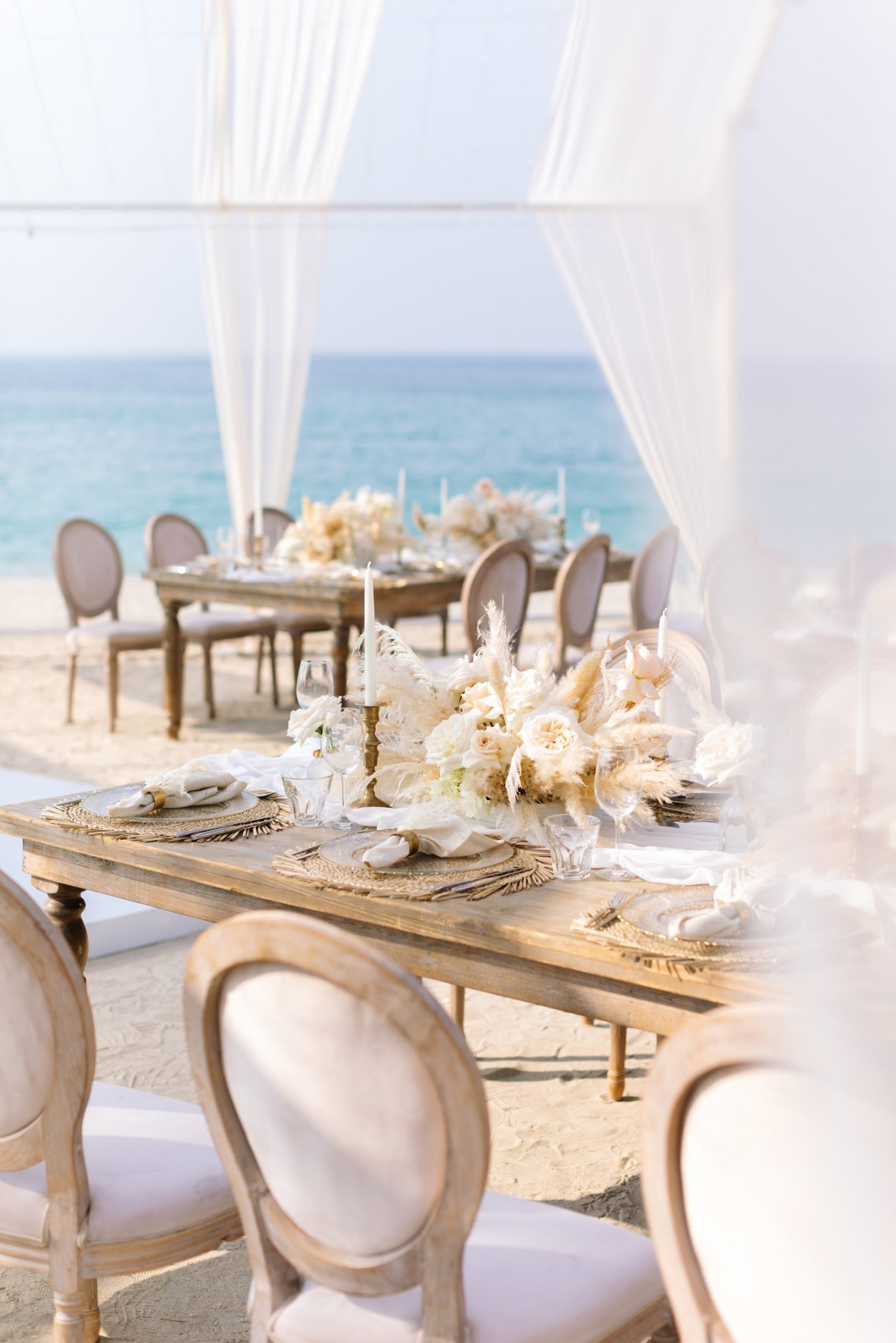 Close up of floral decoration and table number displayed on top of a dining table, sea view behind the table