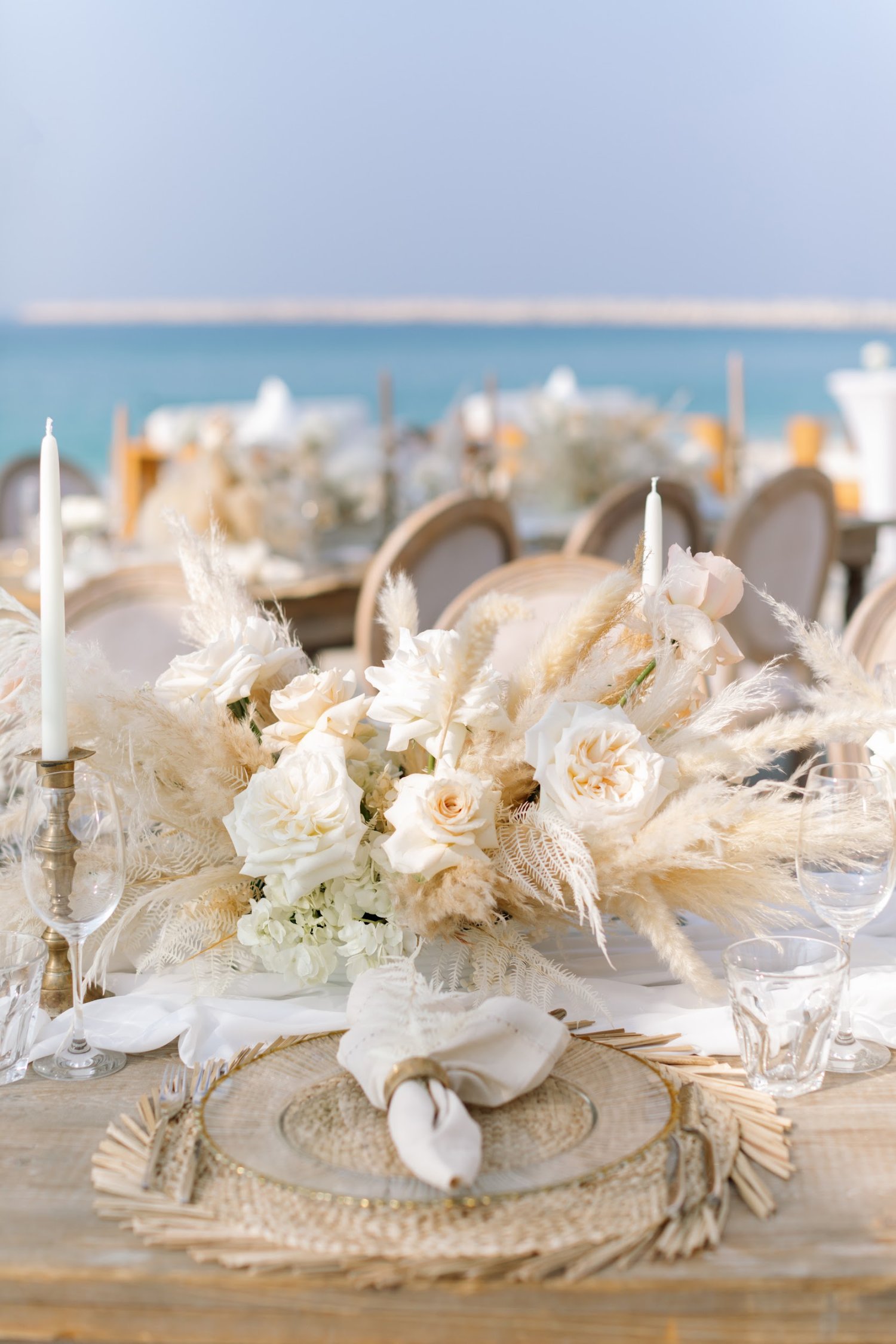 Close up of cream floral tabletop displays and tables set with plates, cutlery and napkins