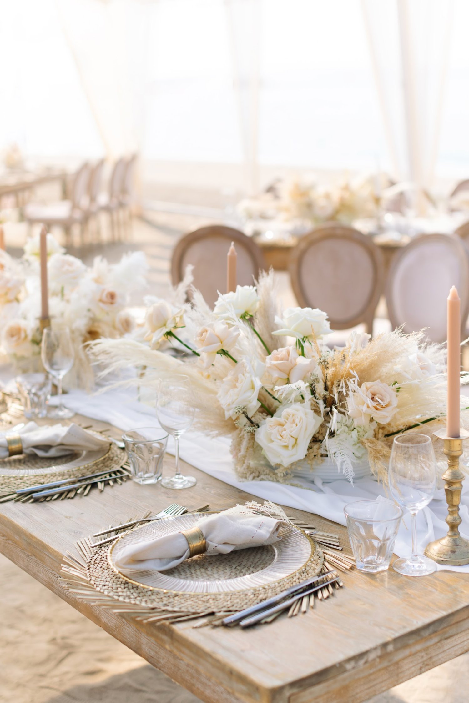 Close up of cream floral tabletop displays and tables set with plates, cutlery and napkins