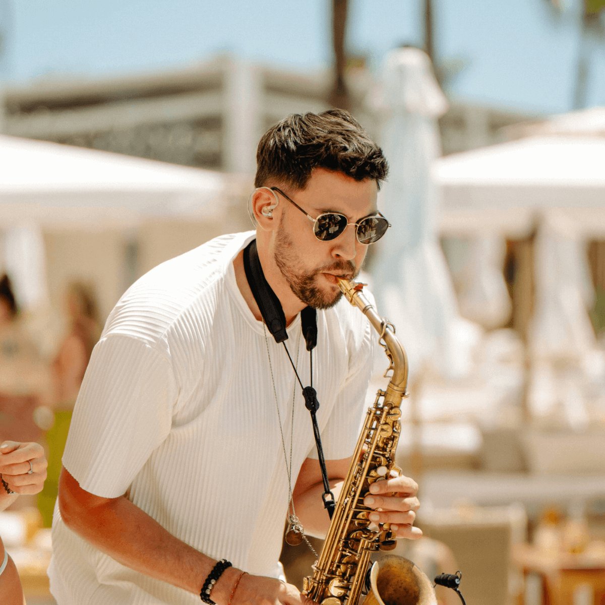 Man playing the saxophone wearing sunglasses