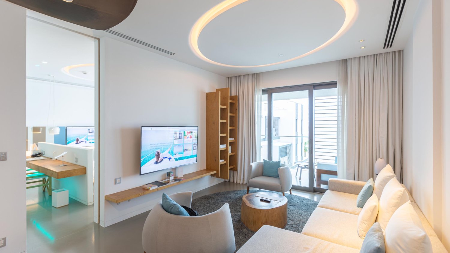 Living room area with sofa, arm chairs and flat screen TV
