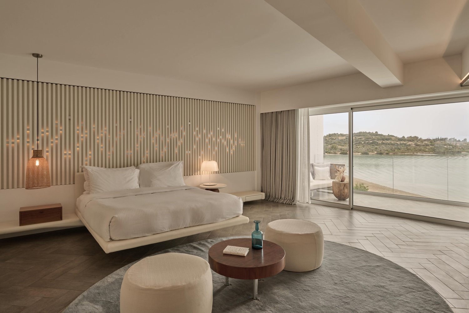 A serene bedroom featuring a bed and a private balcony with stunning ocean views of Porto Heli Bay, perfect for relaxation