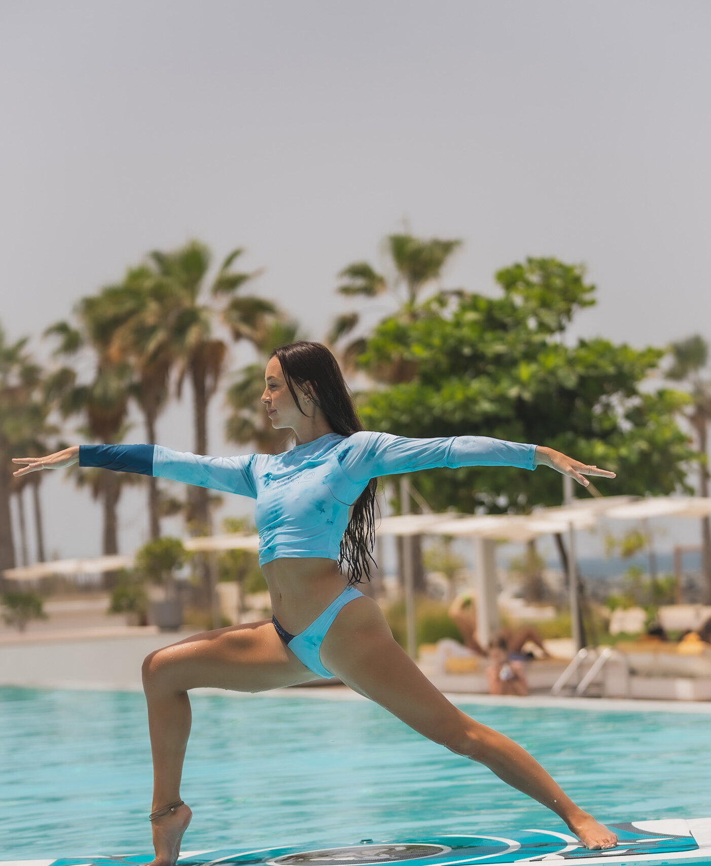 A women doing yoga on a surf board