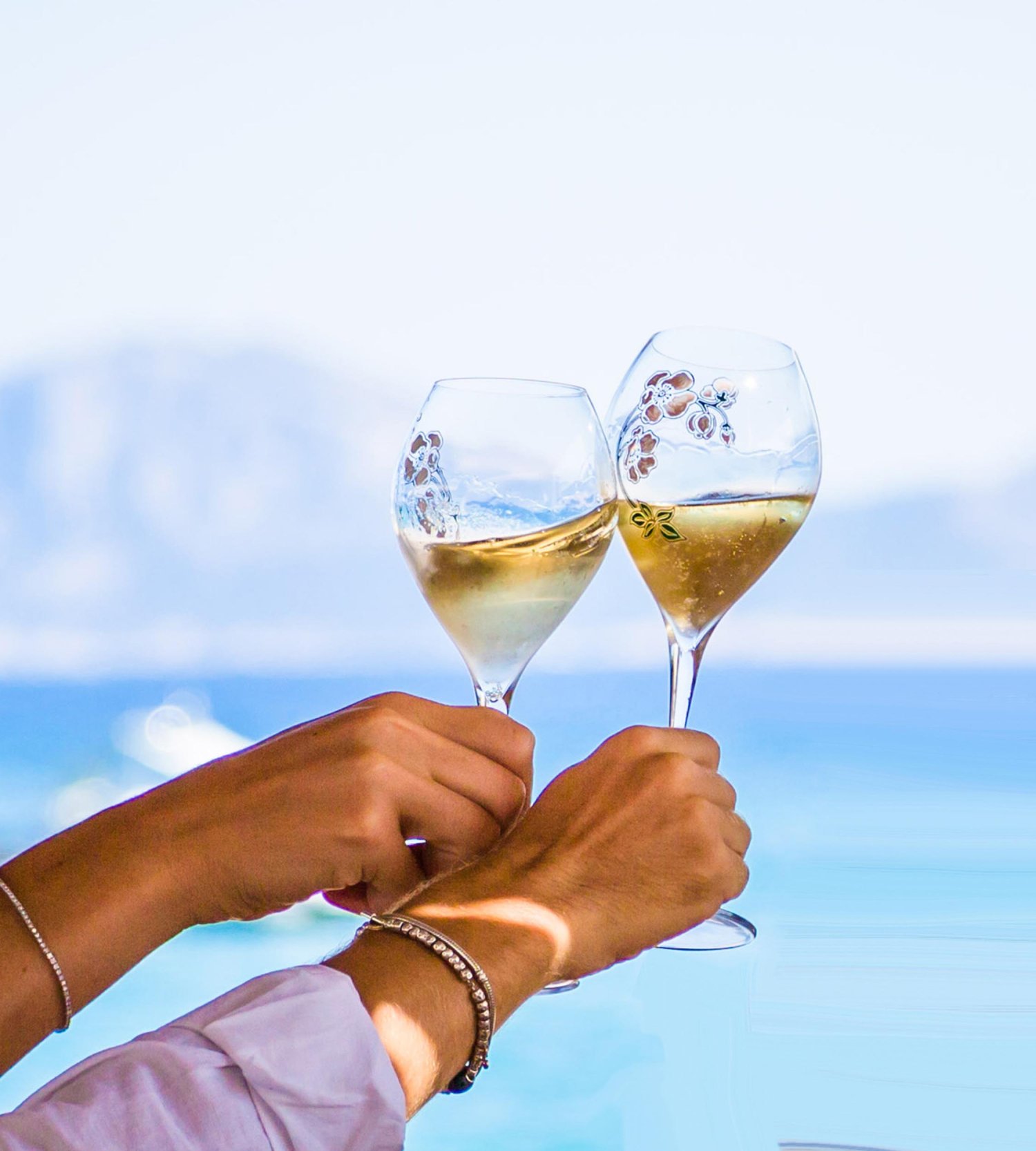 Two people cheersing decretive wine glasses