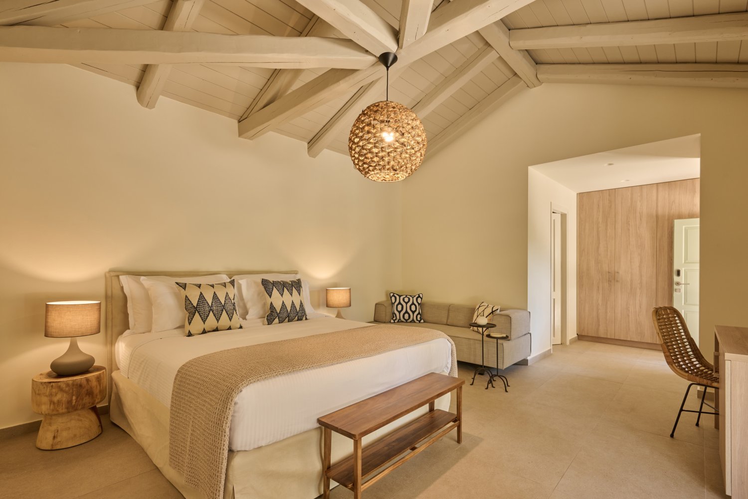 Charming bedroom featuring a luxurious bed, practical desk, and inviting lamp, creating a serene sanctuary by the sea