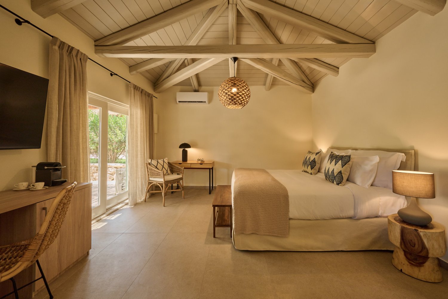 nviting bedroom showcasing a comfortable bed, chic desk, and television, designed for relaxation in a seaside bungalow
